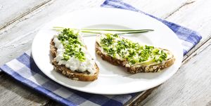 Cottage cheese, butter and chives on whole grain bread, close up
