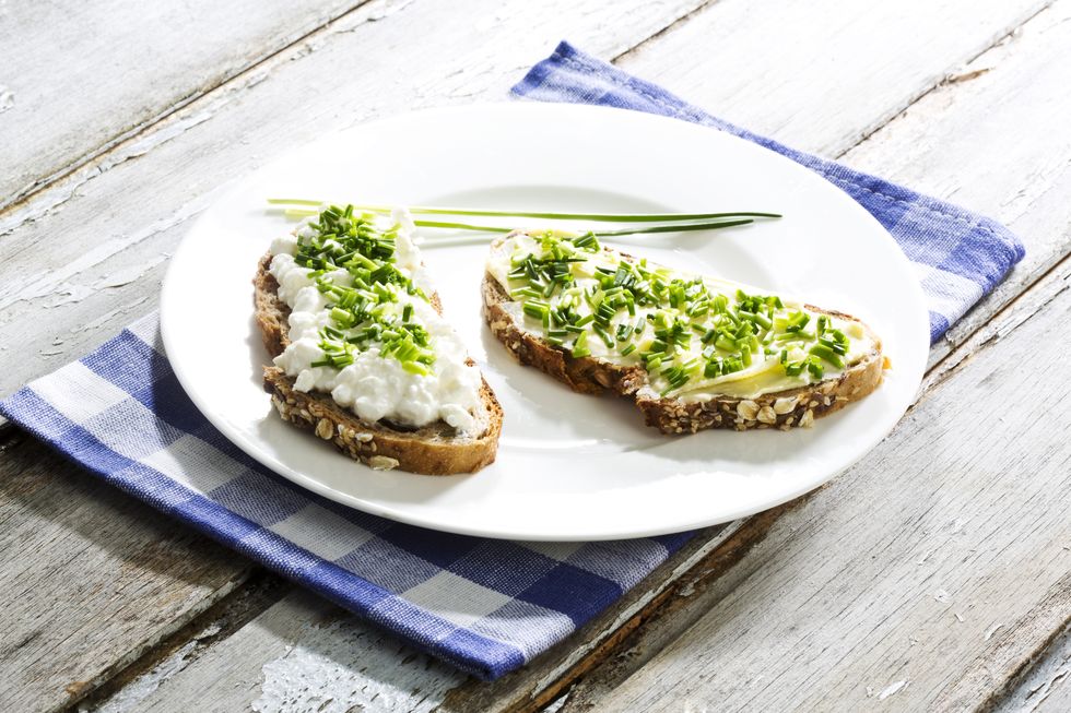 cottage cheese, butter and chives on whole grain bread, close up