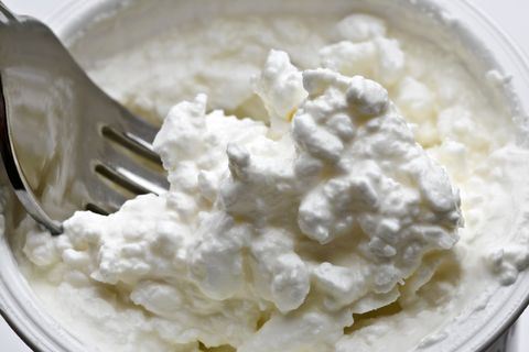 cottage cheese in tub with fork close up