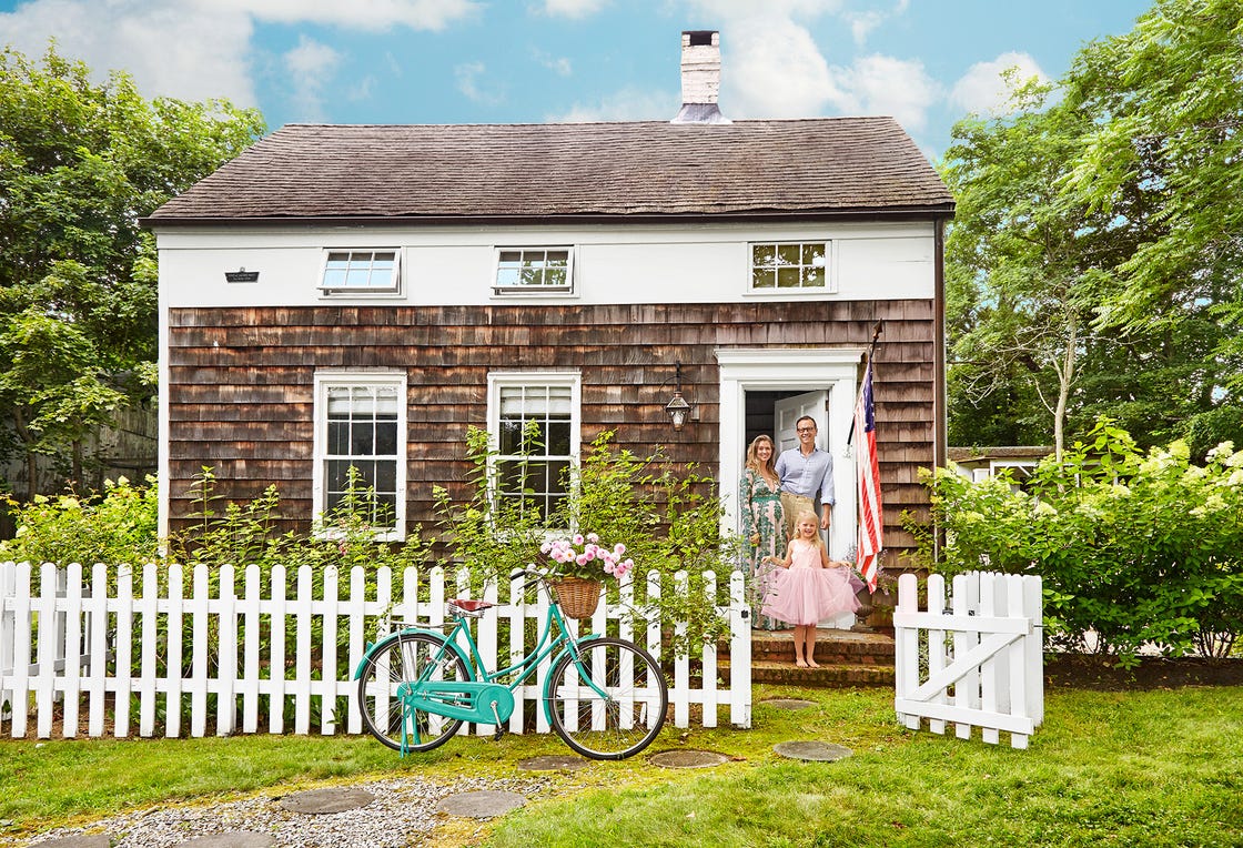 saltbox cottage with shingle siding and white picket fence