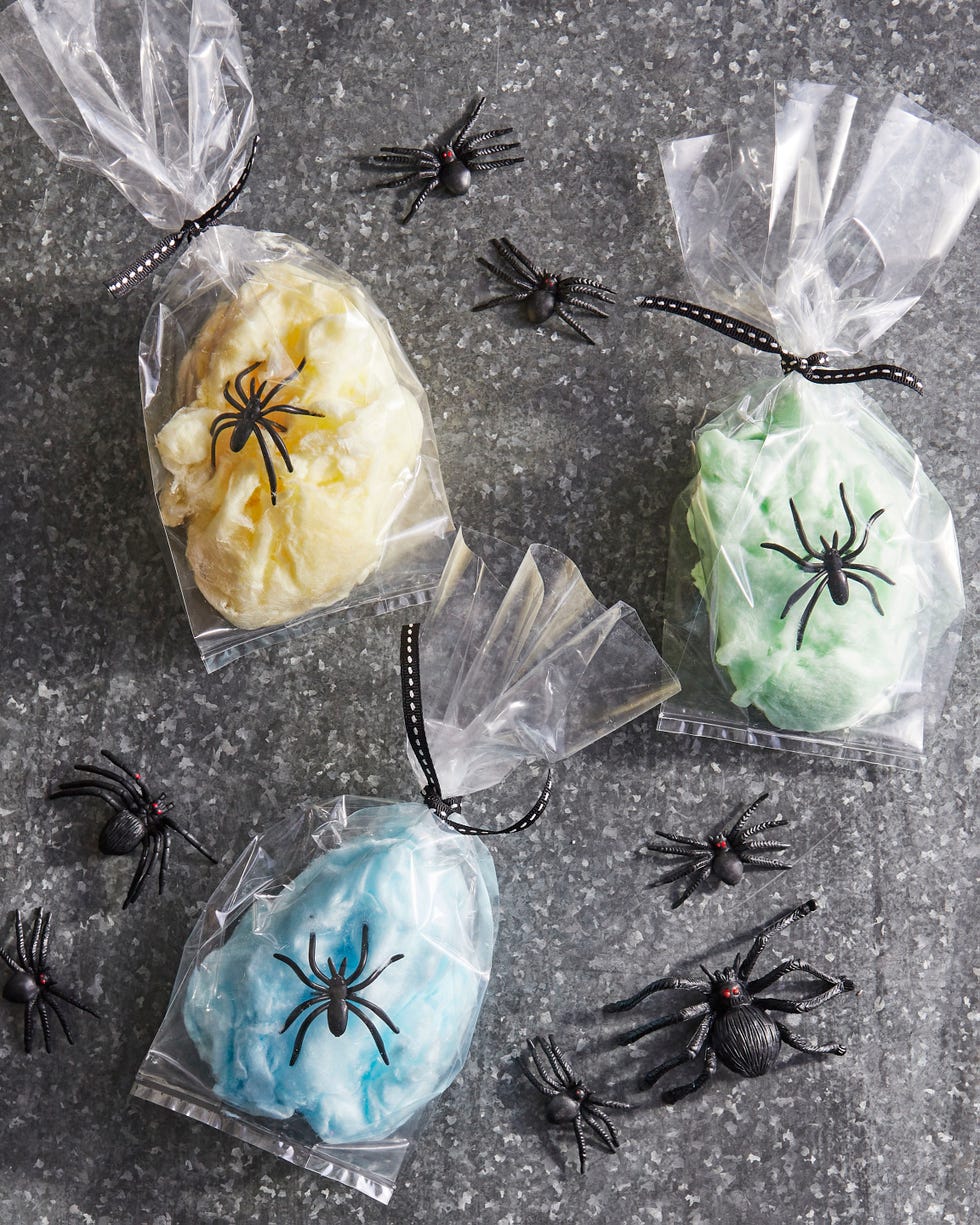 a single serving of cotton candy in a glassine bag with a plastic spider ring resting on top