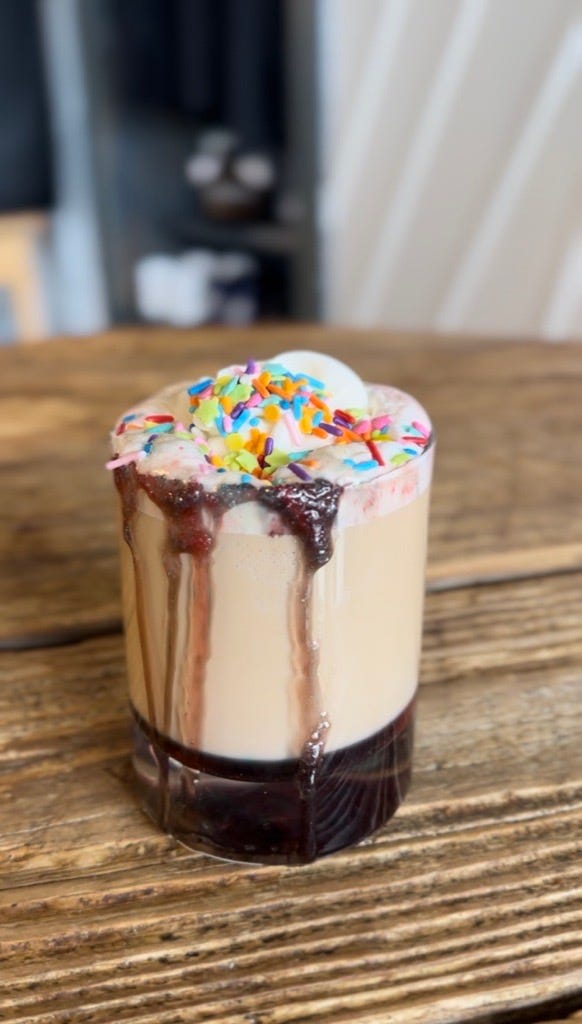 a cupcake with sprinkles on a wooden surface
