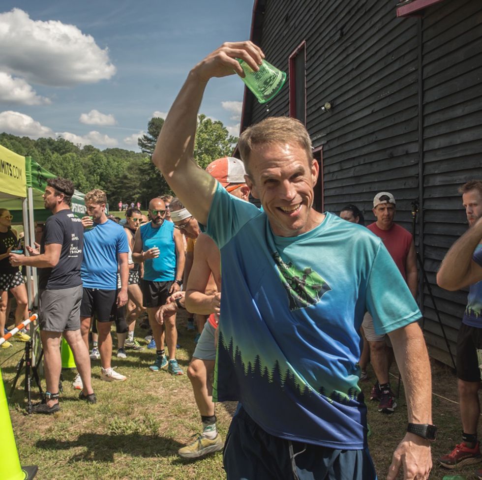 a runner pours an empty beer cup over his head after the cottonmouth beerlay