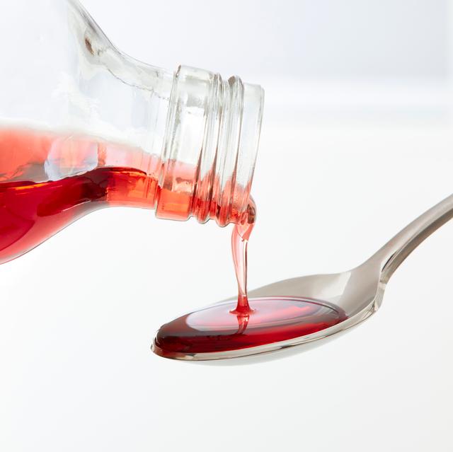 cough syrup being poured onto spoon