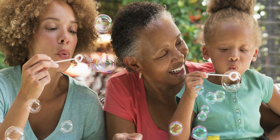 black multigeneration family blowing bubbles