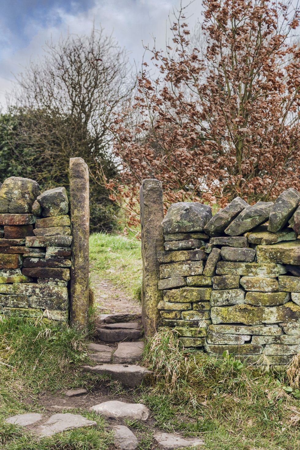 a stile in a drystone wall on a public footpath in the english countryside