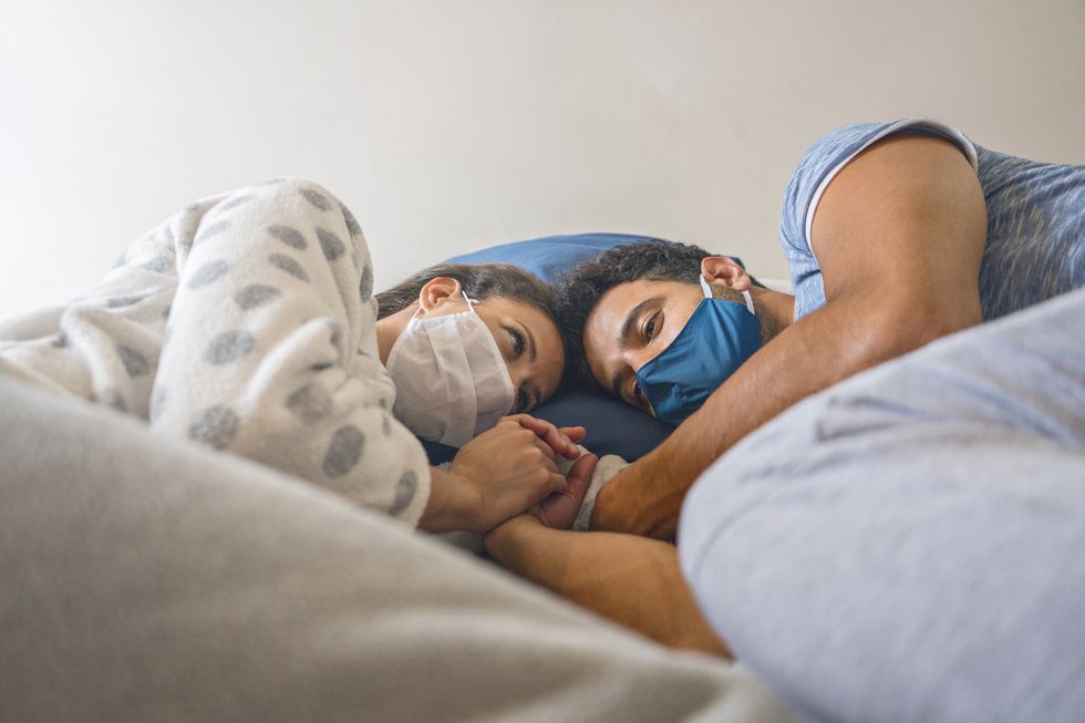 couple at home lying in bed passing quarantine time