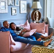 couple at home watching television together on sofa