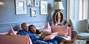 couple at home watching television together on sofa