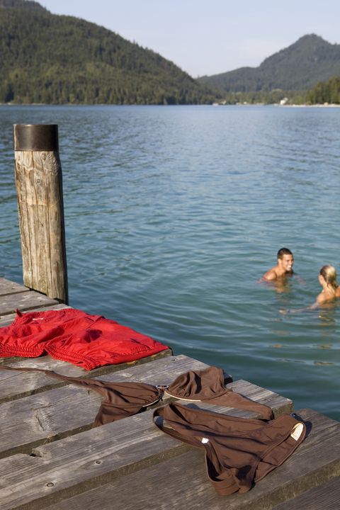 a couple bathing naked in a lake