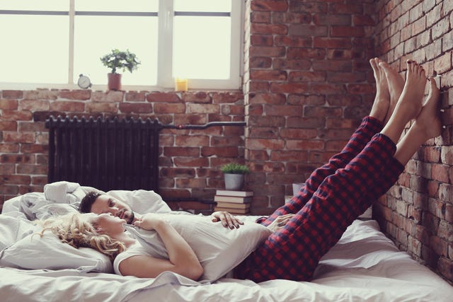 A couple in bed with their legs up
