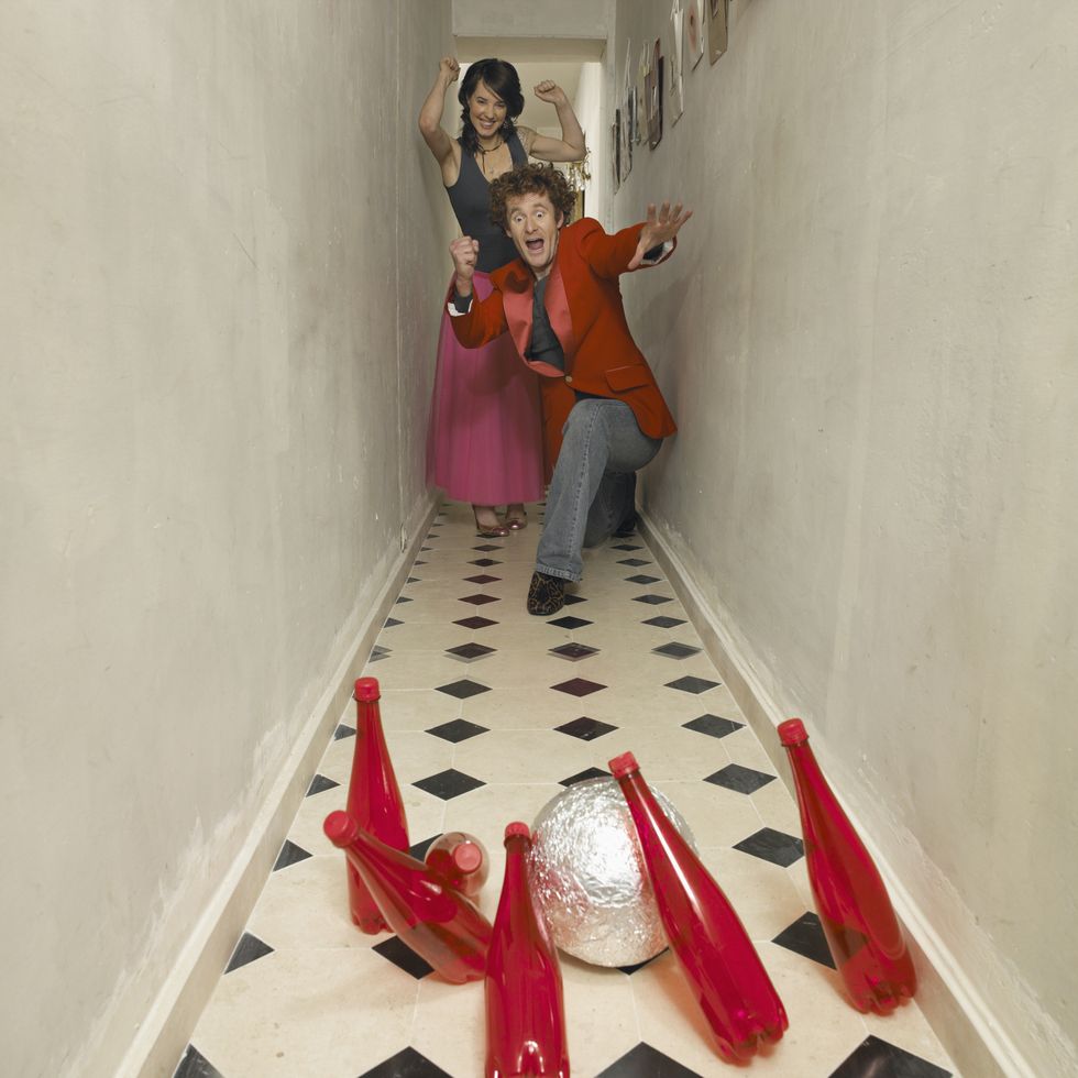 couple bowling with red bottles in hallway