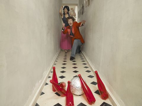 couple bowling with red bottles in hallway