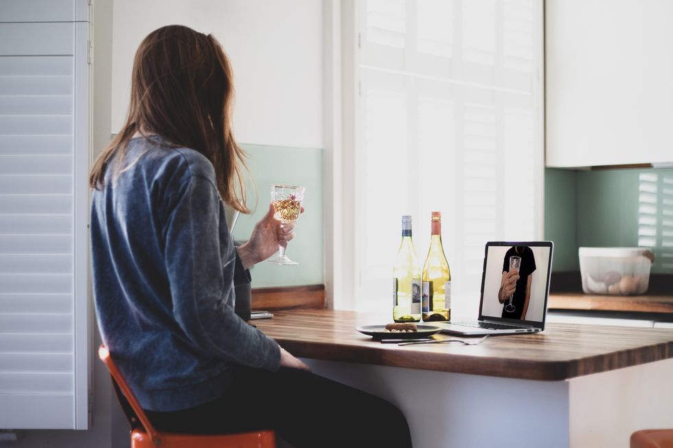 couple celebrating by video conference, with white wine