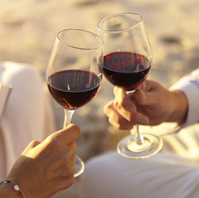couple drinking red wine on beach