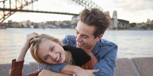 couple embracing in front of Sydney Harbour Bridge