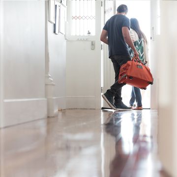 Couple exiting house with luggage