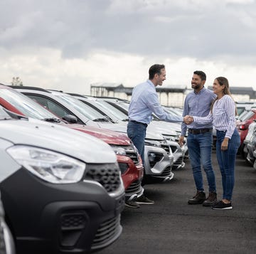 Couple handshaking with a car salesperson after buying a car couple handshaking with a car salesperson after buying a car