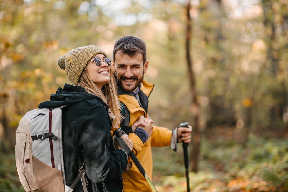 male and female couple hiking in the forest during the fall