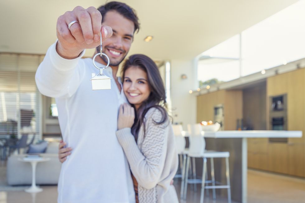 couple holding a house key in their new home