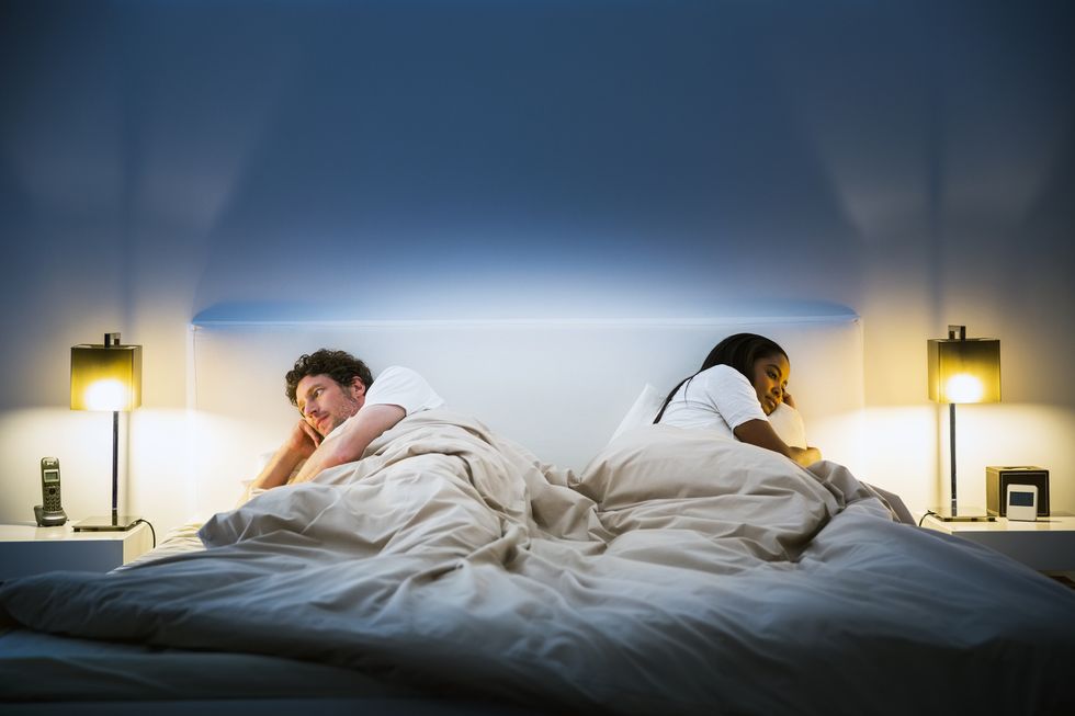 couple ignoring each other on bed