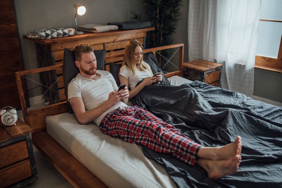 couple in bed using mobile phones
