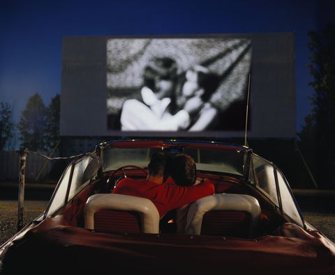 couple in convertible car watching film at drive in composite