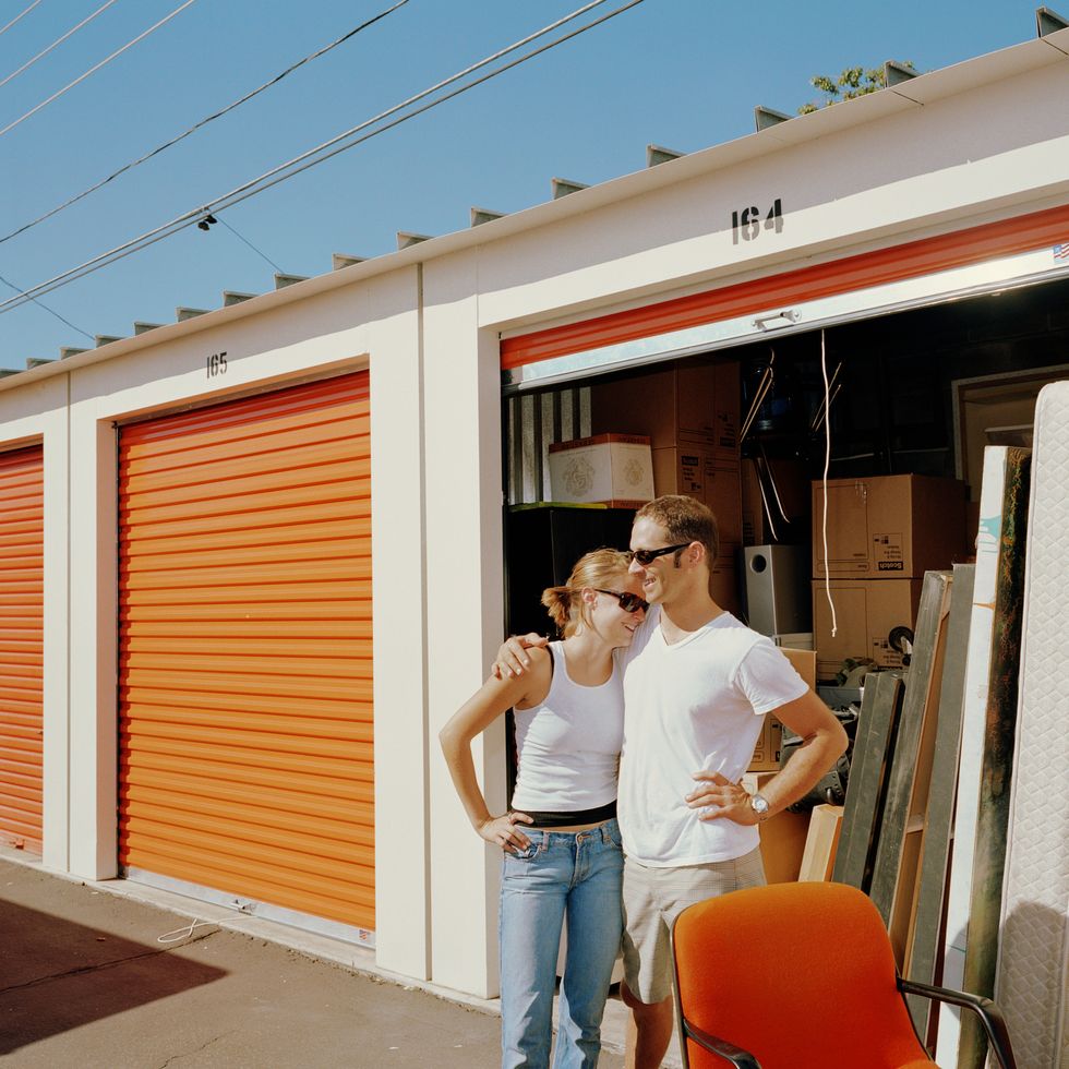 couple in front of storage shed, man's arm around woman