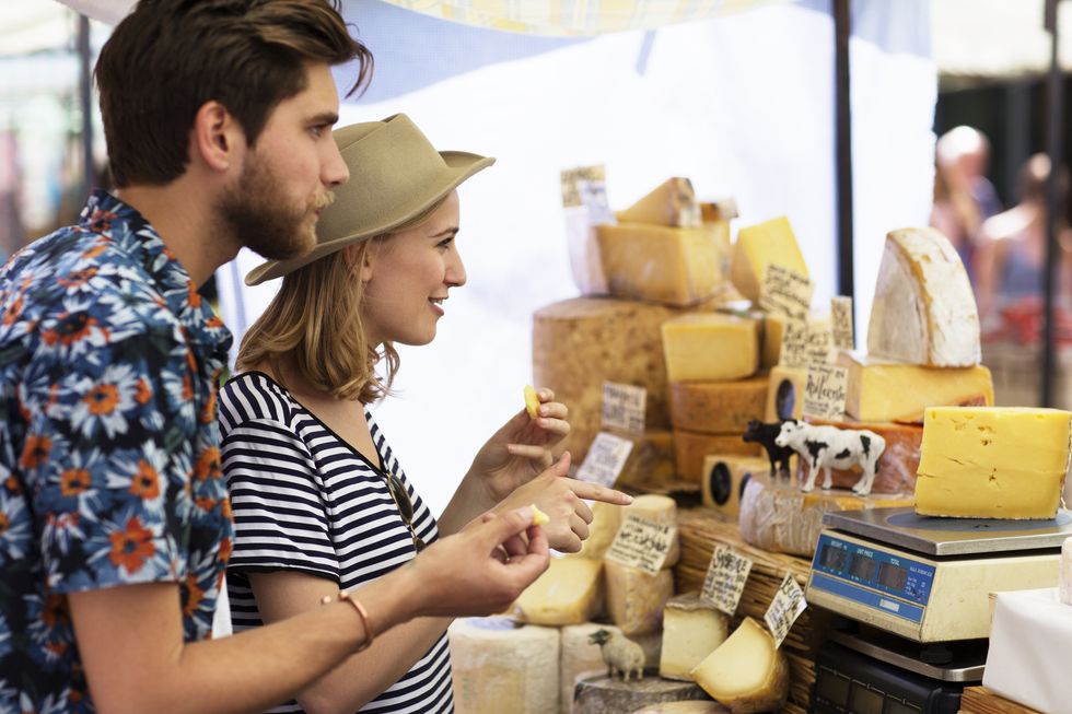 Couple in market at cheese stall