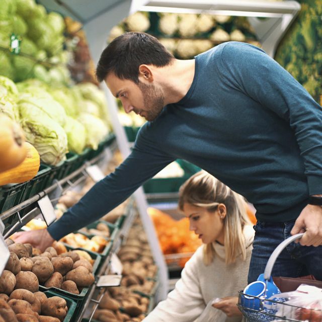 couple in supermarket buying vegetables