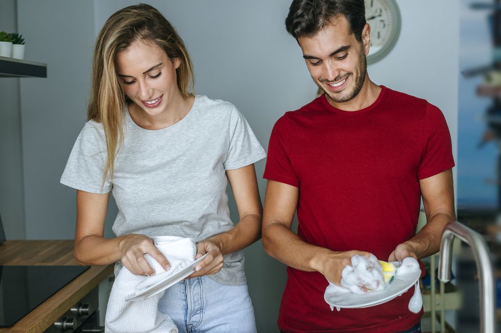 couple indoors washing dishes