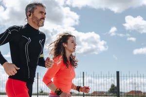 couple jogging against cloudy sky