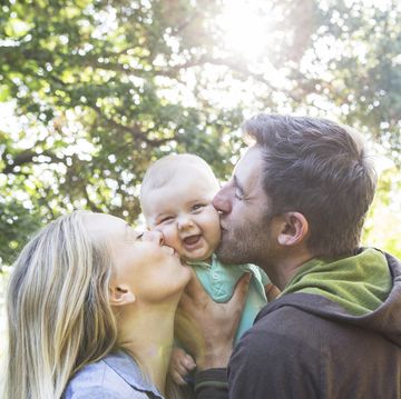 couple kissing their baby