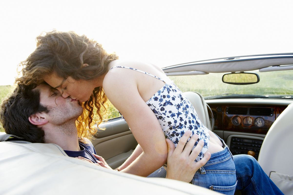 couple kissing in a convertible