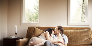 couple kissing while relaxing on sofa