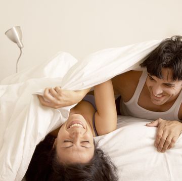 couple laughing in bed together