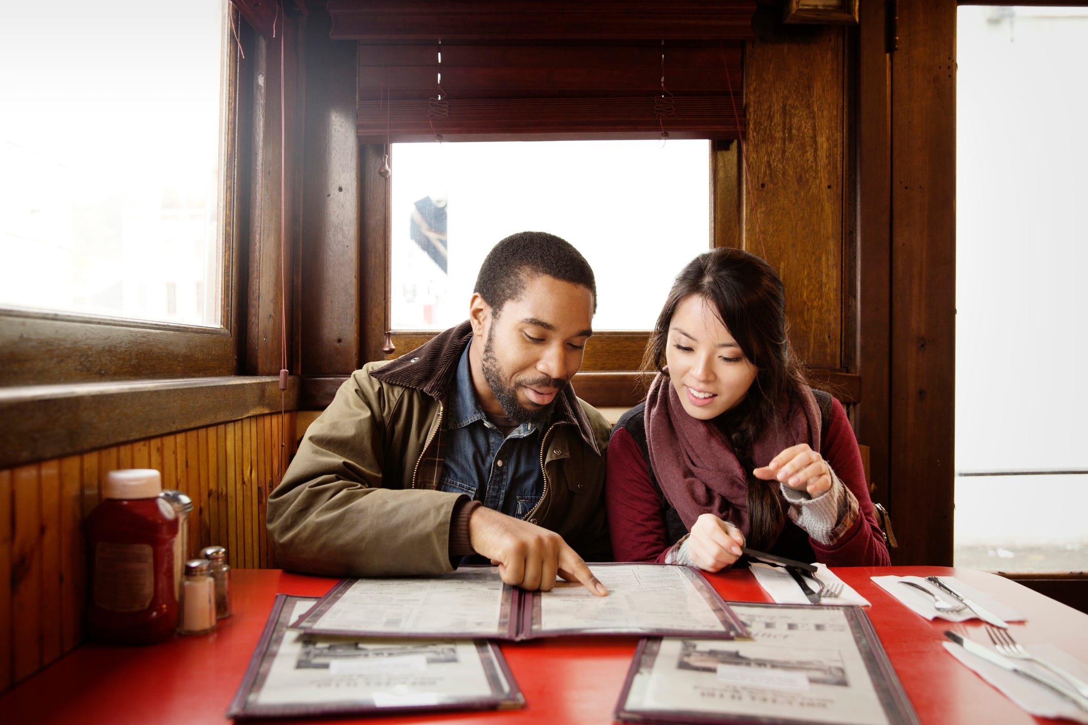 couple looking at menu while sitting in restaurant