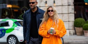emily sindlev draagt oranje oversized blouse tijdens copenhagen fashion week met haar vriend mads emil