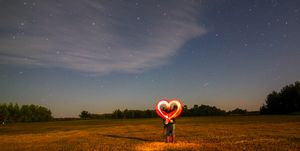 couple making heart shape with wire wools on land at night