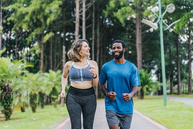 two people walking down paved path in workout gear