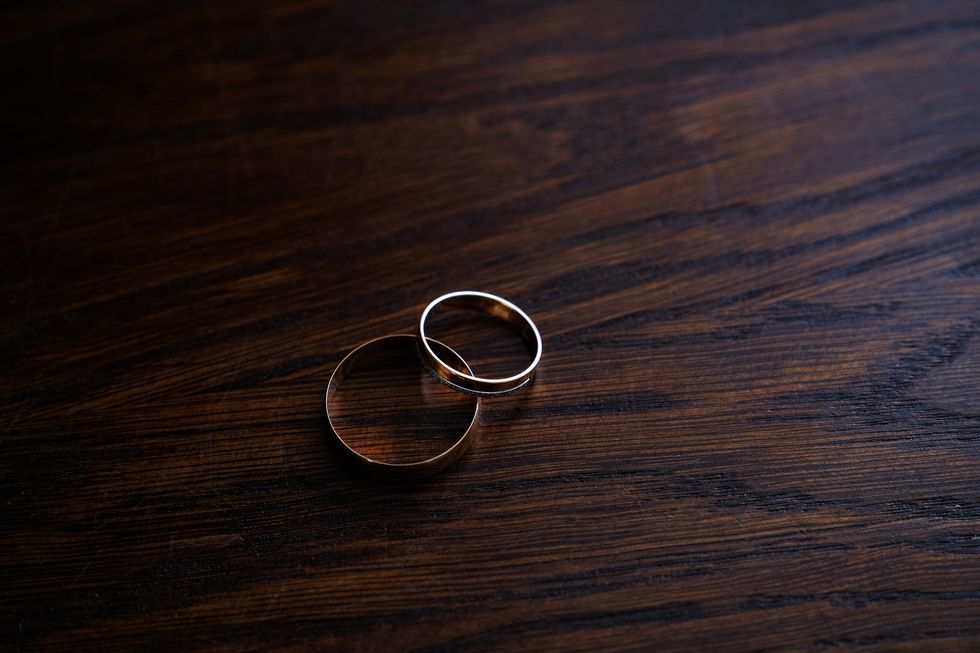 couple of wedding rings on wooden table