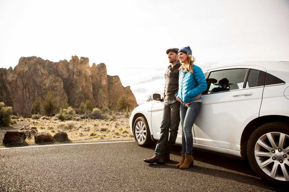 valentines day activities couple standing outside a white car in the mountains