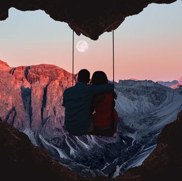 couple on swing contemplating the mountains in a romantic view with heart shape