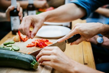 couple preparing food together at barbecue with friends