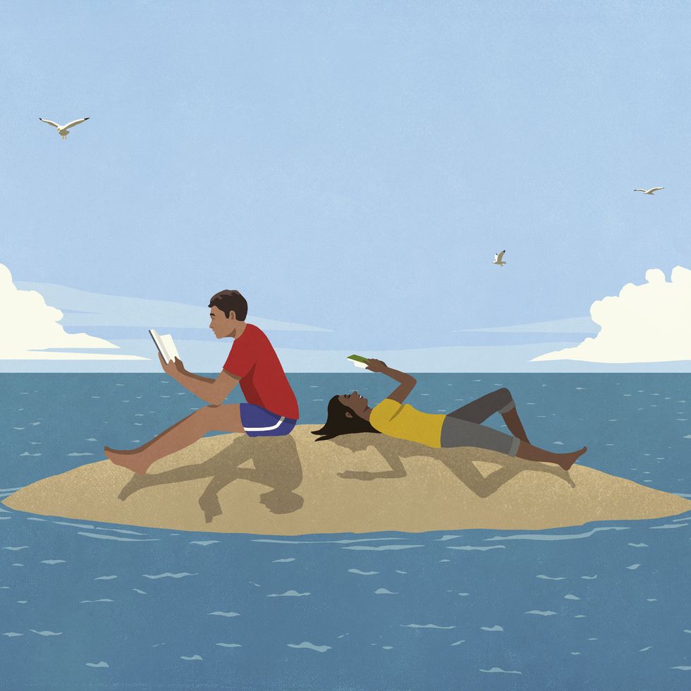 couple reading books on sunny remote ocean island