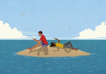 couple reading books on sunny remote ocean island