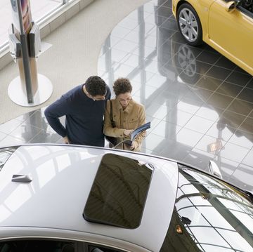 couple reading car information at dealership