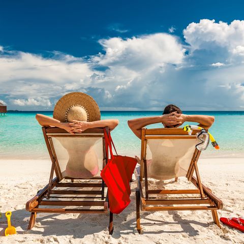 couple in loungers on beach at maldives