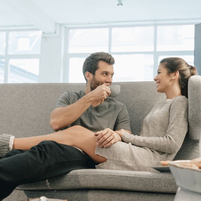 couple relaxing on couch at home having breakfast
