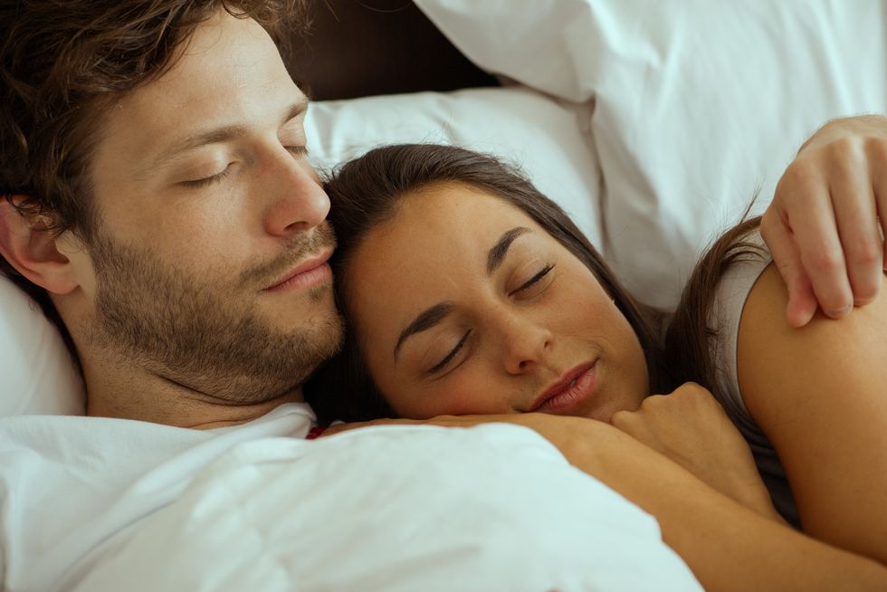 Couple resting and embracing in bed